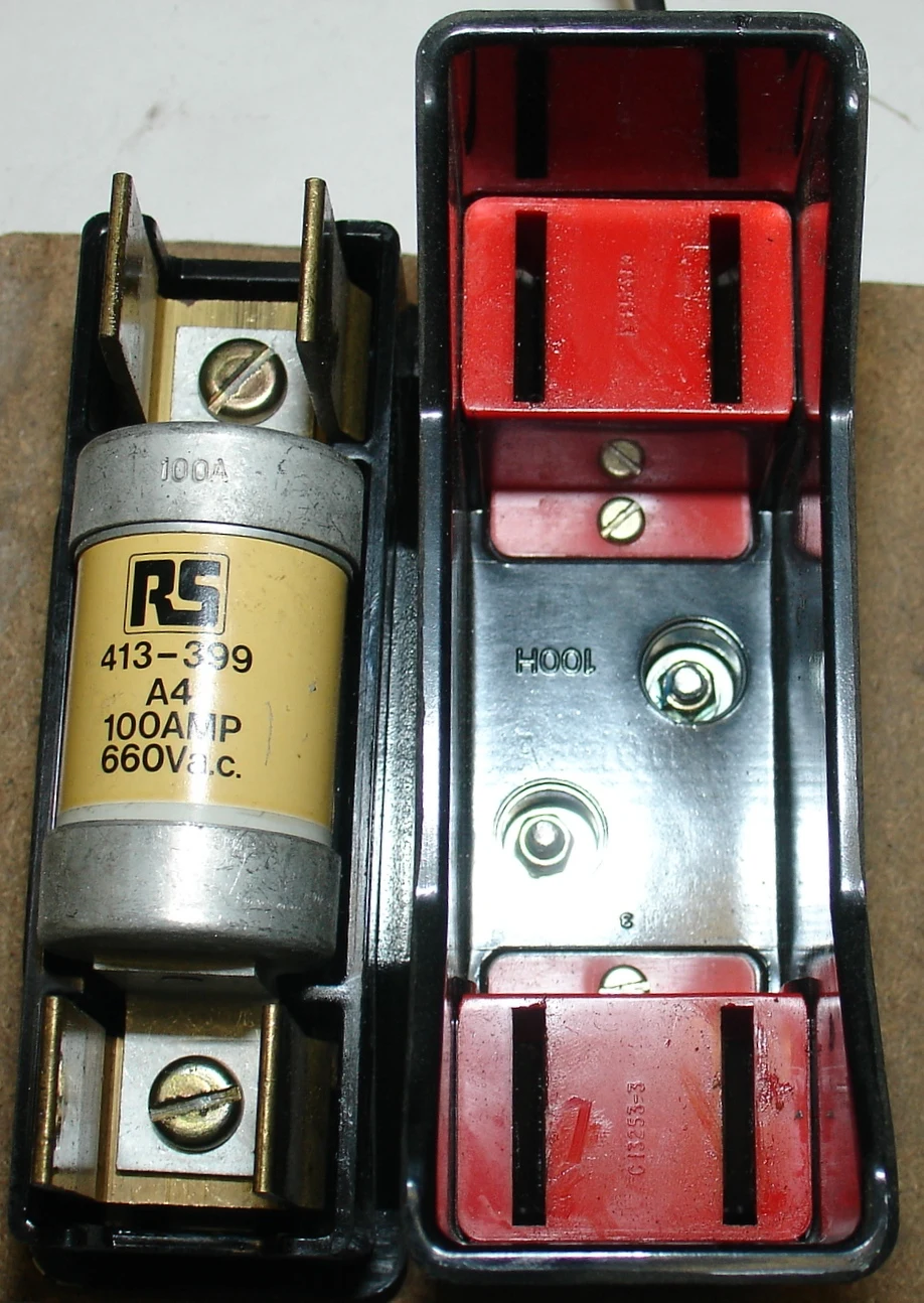 Open industrial fuse holder beside a 100 ampere cartridge fuse; representative family image, not a Mersen BFF32A1 photograph.